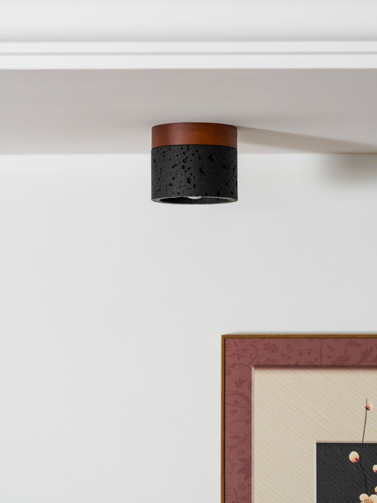 Unlit, this Clérachic flush ceiling light sits at a white ceiling edge, a pink-framed print on the wall beneath.