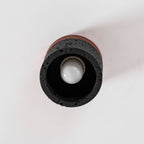 Looking up at the open base of a Clérachic flush ceiling light, with a round white bulb inside a dark, porous stone ring.