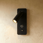 A matte black version of the wall reading light shows the same adjustable spot, switch and USB port, Clérachic hero shot.