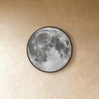 Clérachic moon wall lamp shown unlit, displaying the engraved grey lunar surface art against a plaster wall.