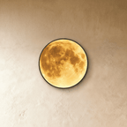 Clérachic illuminated moon wall lamp viewed straight-on, its warm amber glow lighting the lunar surface art.