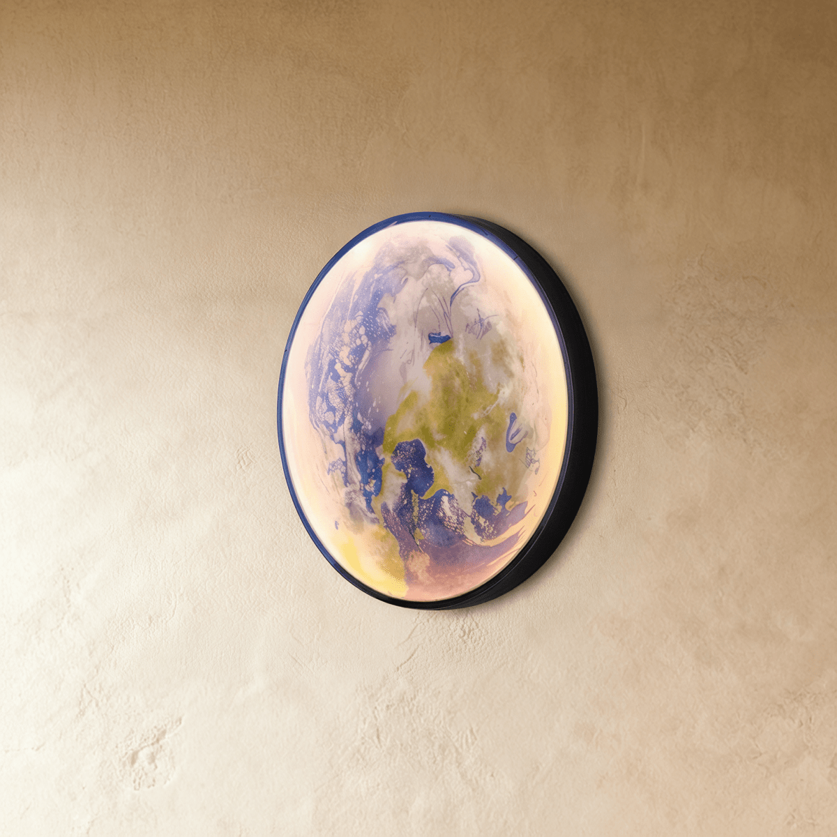 Clérachic illuminated Earth wall lamp in blue and green tones, angled to show its curved glass surface against plaster.