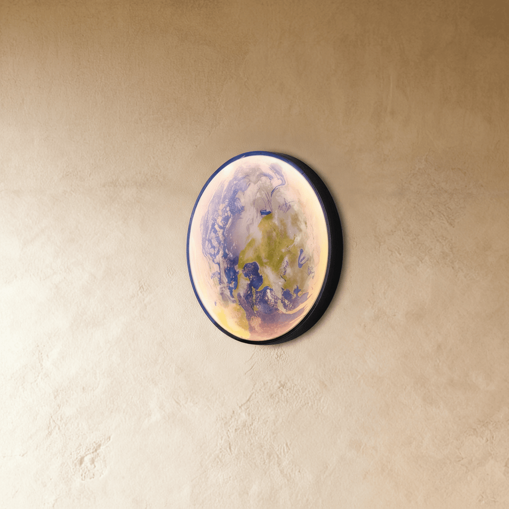 Clérachic illuminated Earth wall lamp in blue-green tones, its curved glass catching the light at an angle.