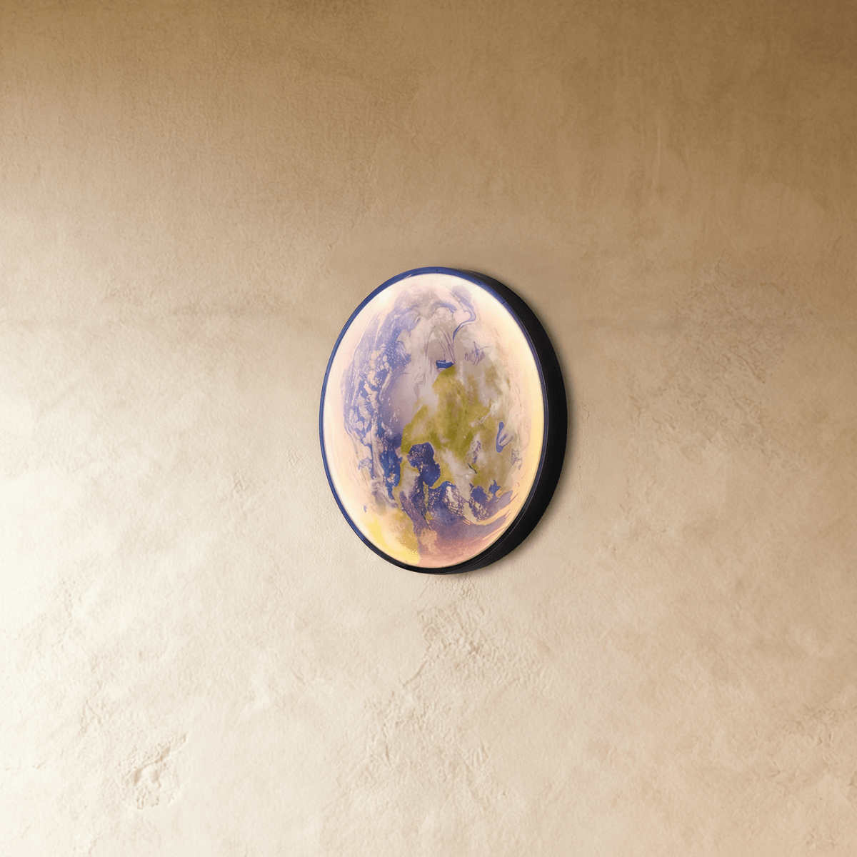 Clérachic illuminated Earth wall lamp glowing in soft blue and green, viewed from a side angle against plaster.