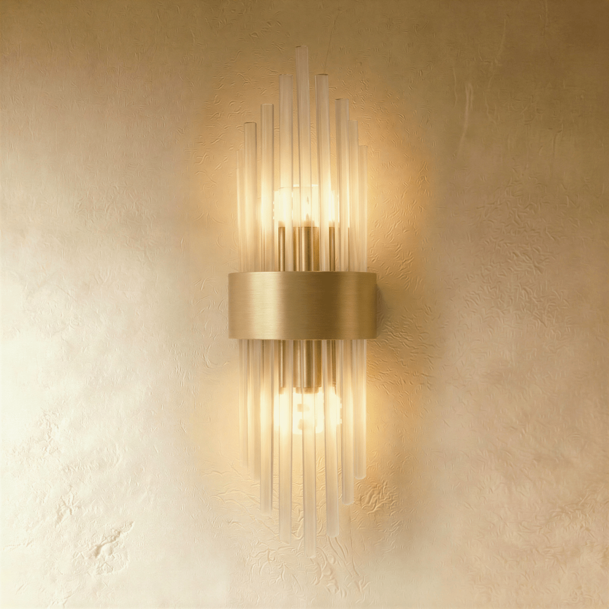 Clérachic brass wall sconce with fluted glass rods radiating from a rectangular gold-tone backplate against plaster.