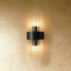 Clérachic black metal wall sconce with fluted glass rods radiating from a rectangular backplate against plaster.