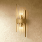 Clérachic brass wall sconce with long fluted glass rods and twin metal posts on a slim gold-tone backplate.