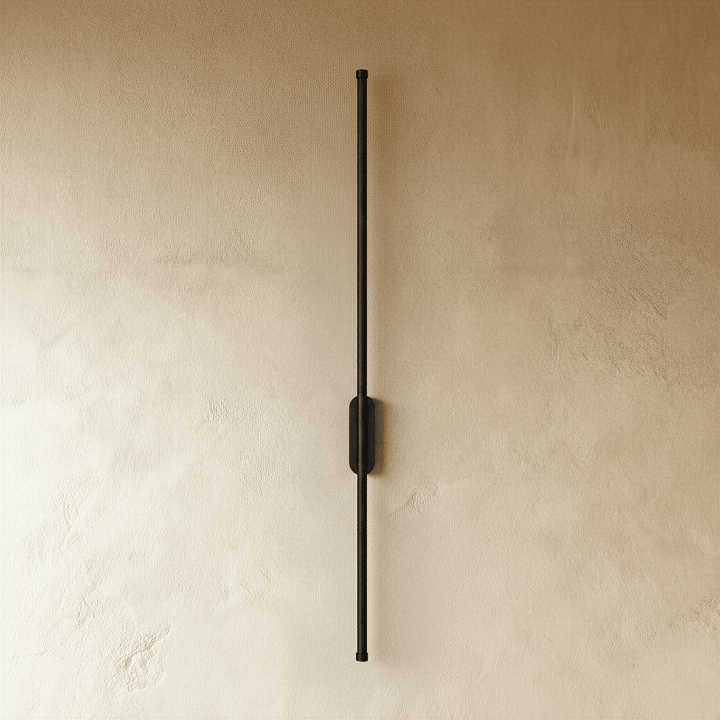 Clérachic black slim wall light shown unlit, a thin rod fixed by an oval canopy to a plaster wall.