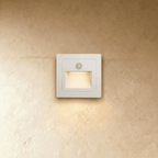 The same recessed step light in white shows its motion sensor eye and angled light chamber in this Clérachic hero shot.
