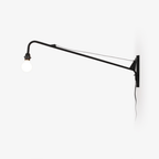 Black swing-arm wall light from Clérachic on a white wall, with a braced arm, a round white globe bulb and a trailing cord.