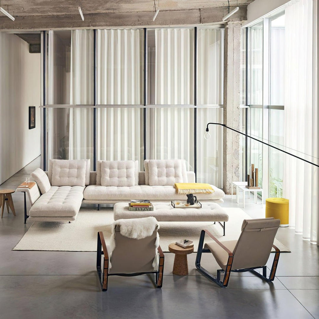 Wide shot of a loft lounge, with a black Clérachic swing-arm wall light reaching from the right-hand wall above the seating.