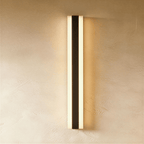 Another straight-on view shows the black aluminium column sconce's twin light strips against bare plaster, Clérachic hero shot.