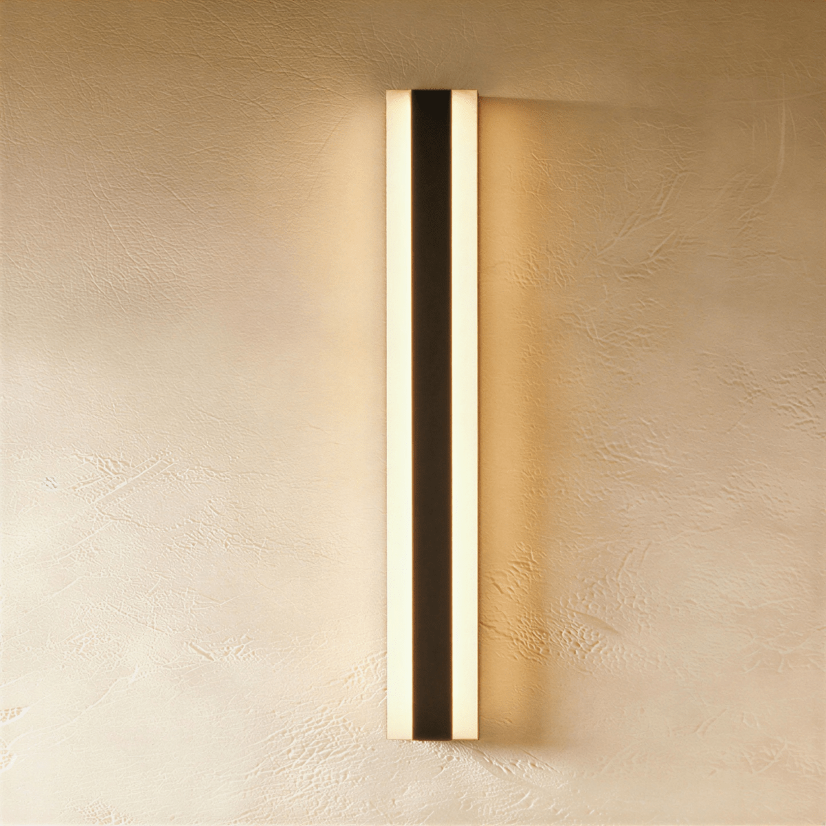 Another straight-on view shows the black aluminium column sconce's twin light strips against bare plaster, Clérachic hero shot.