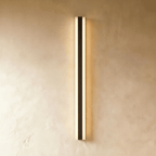 A final studio view of the black aluminium column sconce shows its slim profile glowing warm on plaster, Clérachic hero shot.
