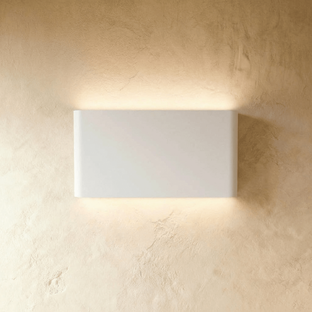 A mid-size white up-down sconce glows evenly above and below its rectangular body, Clérachic hero shot.