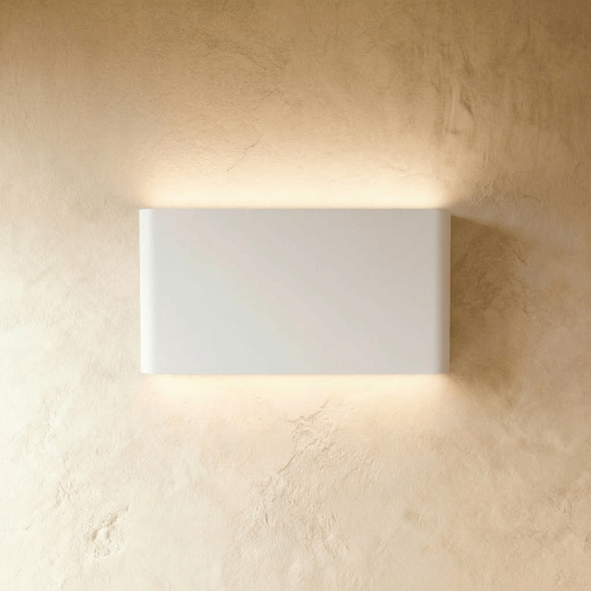 A mid-size white up-down sconce glows evenly above and below its rectangular body, Clérachic hero shot.