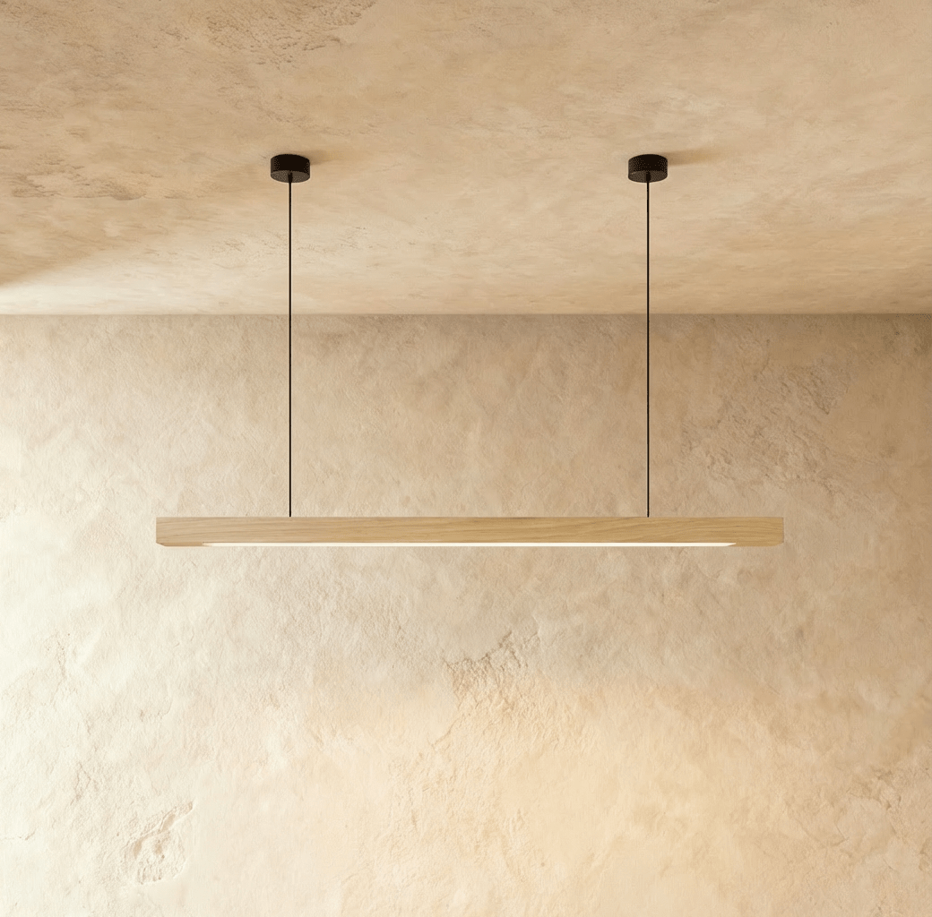 Clérachic's pine wood pendant bar hangs from two round black ceiling canopies against a plaster wall.