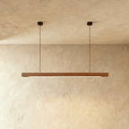 Clérachic's black walnut pendant bar hangs from two round black canopies, its dark grain catching the light.
