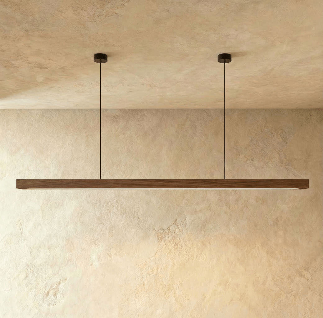 The Clérachic black walnut pendant bar's dark wood grain is lit from below its two round canopies.
