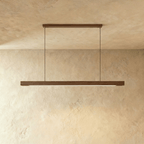 This Clérachic black walnut pendant bar hangs from its horizontal canopy, dark grain lit from below.