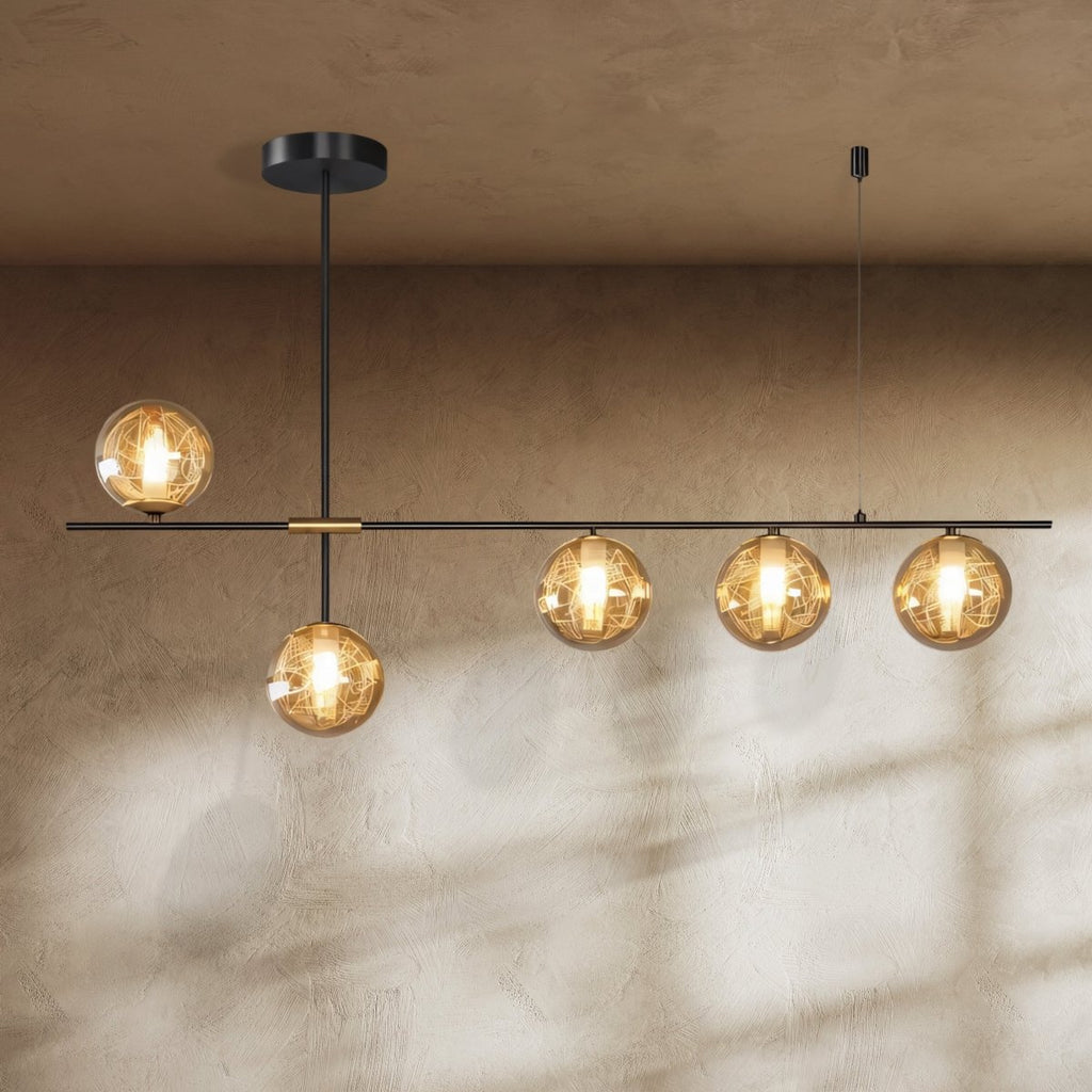 Clérachic 5-head linear chandelier with amber textured glass globes on a black bar, glowing against a limewash wall.