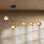 Clérachic 5-head linear chandelier with amber textured glass globes on a black bar, glowing against a limewash wall.