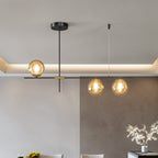 Clérachic 3-head chandelier with amber globes on a black bar above a dining area with a lit ceiling cove.