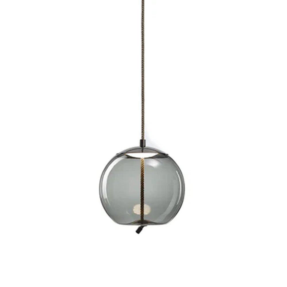 On a plain white backdrop, a round smoke-grey glass Clérachic pendant shows its dark metal cap and braided cord running through the glass.