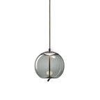 On a plain white backdrop, a round smoke-grey glass Clérachic pendant shows its dark metal cap and braided cord running through the glass.