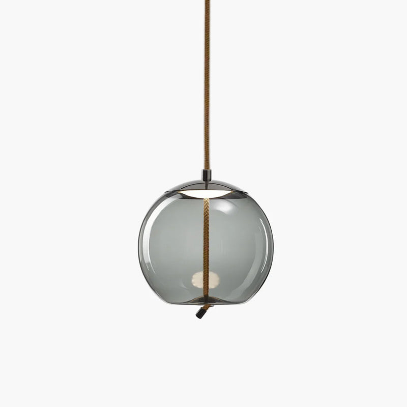 A round smoke-grey glass Clérachic pendant with a dark metal cap and a looped rope tail hangs on a pale backdrop.