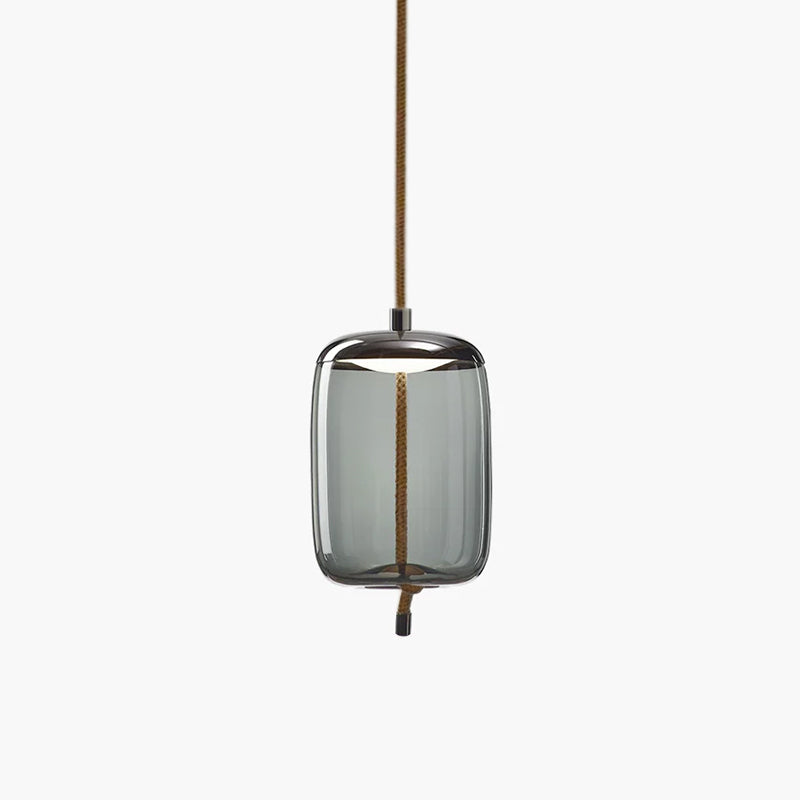 A tall smoke-grey glass Clérachic pendant with a dark metal cap and a knotted rope tail hangs on a pale backdrop.