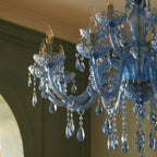 Close view of Clérachic blue chandelier arms, faceted cut-glass bobeches and crystal drops, with candle-style bulbs