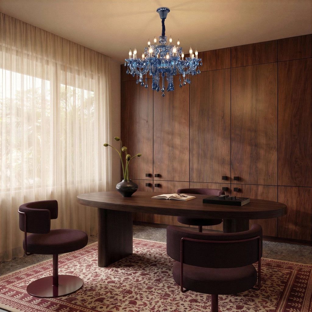Clérachic blue crystal chandelier lit above an oval walnut desk with two plum swivel chairs in a wood-panelled study
