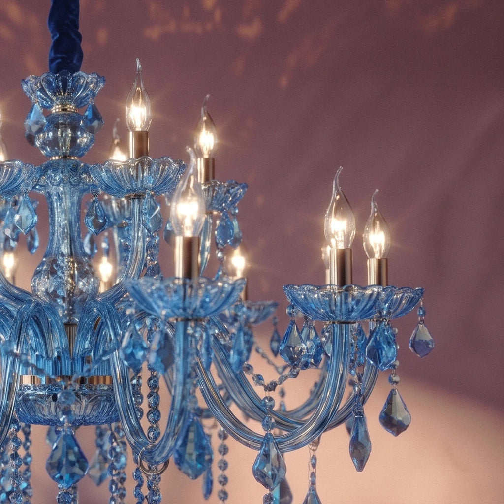 Close view of Clérachic blue glass arms, cut-glass cups and warm candle bulbs against a plum wall