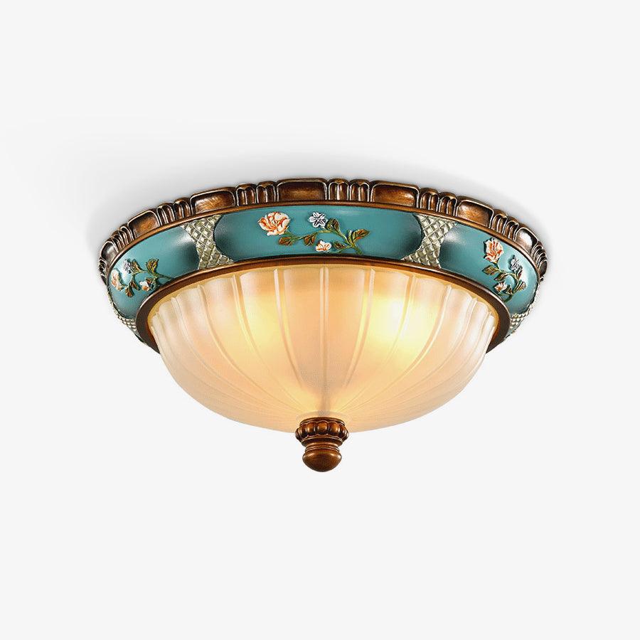Glowing Clérachic ceiling light on a pale backdrop, the turquoise floral band, ribbed glass bowl and brown finial all in view.