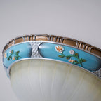 Close view of the turquoise resin band on this Clérachic ceiling light, with painted flowers, silver lattice panels and a brown rim.