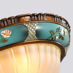 Close view of the floral band and ribbed glass edge of this Clérachic ceiling light, with painted flowers and a patterned silver inset.