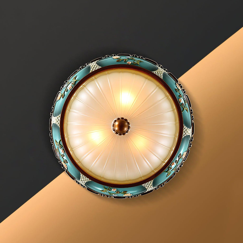 Looking up at this Clérachic ceiling light from below, three lamps glowing behind the frosted glass inside a turquoise flower-decorated rim.