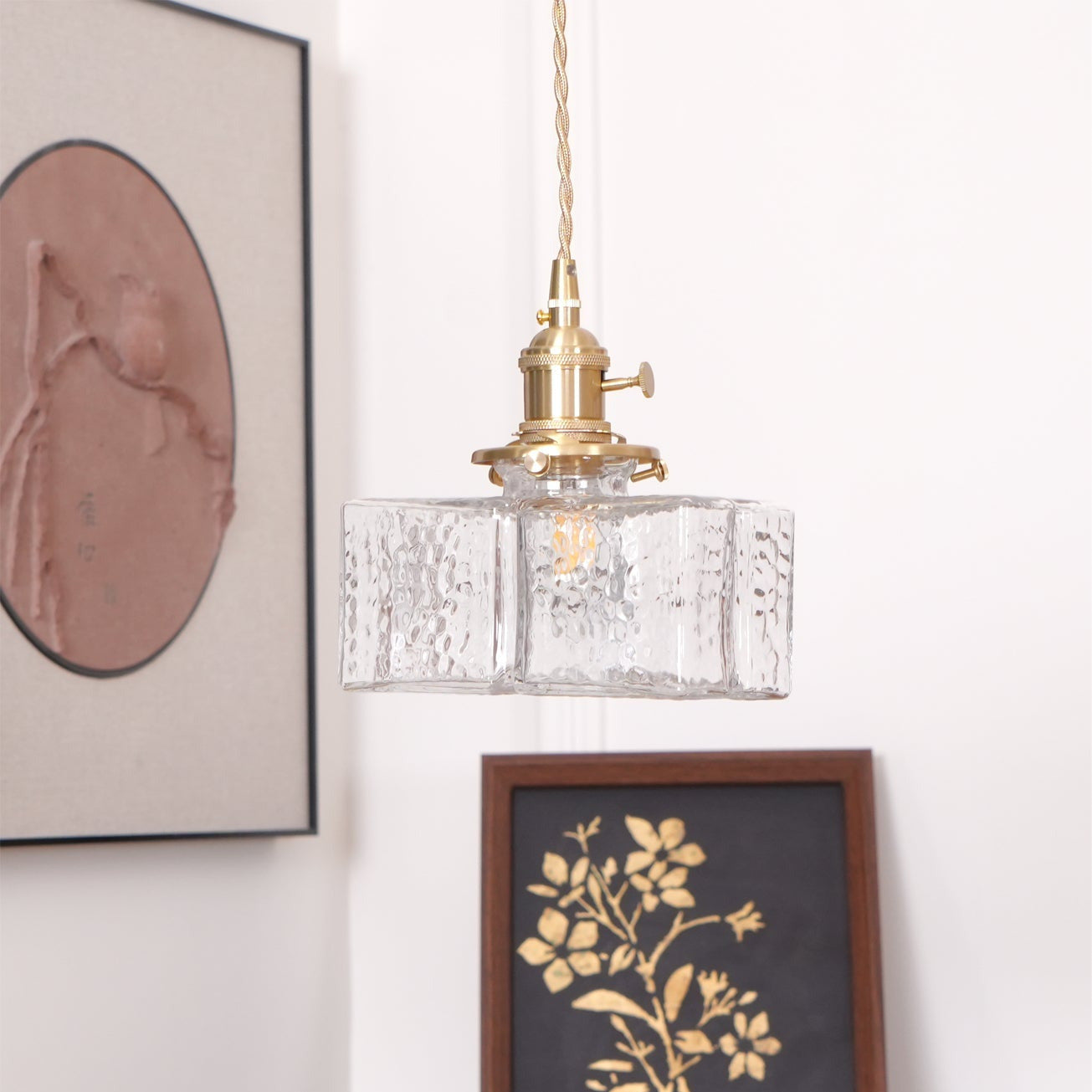Clérachic boxy hammered-glass pendant light, wide-rectangle Model B, lit and hung near a leaning gallery wall of art.