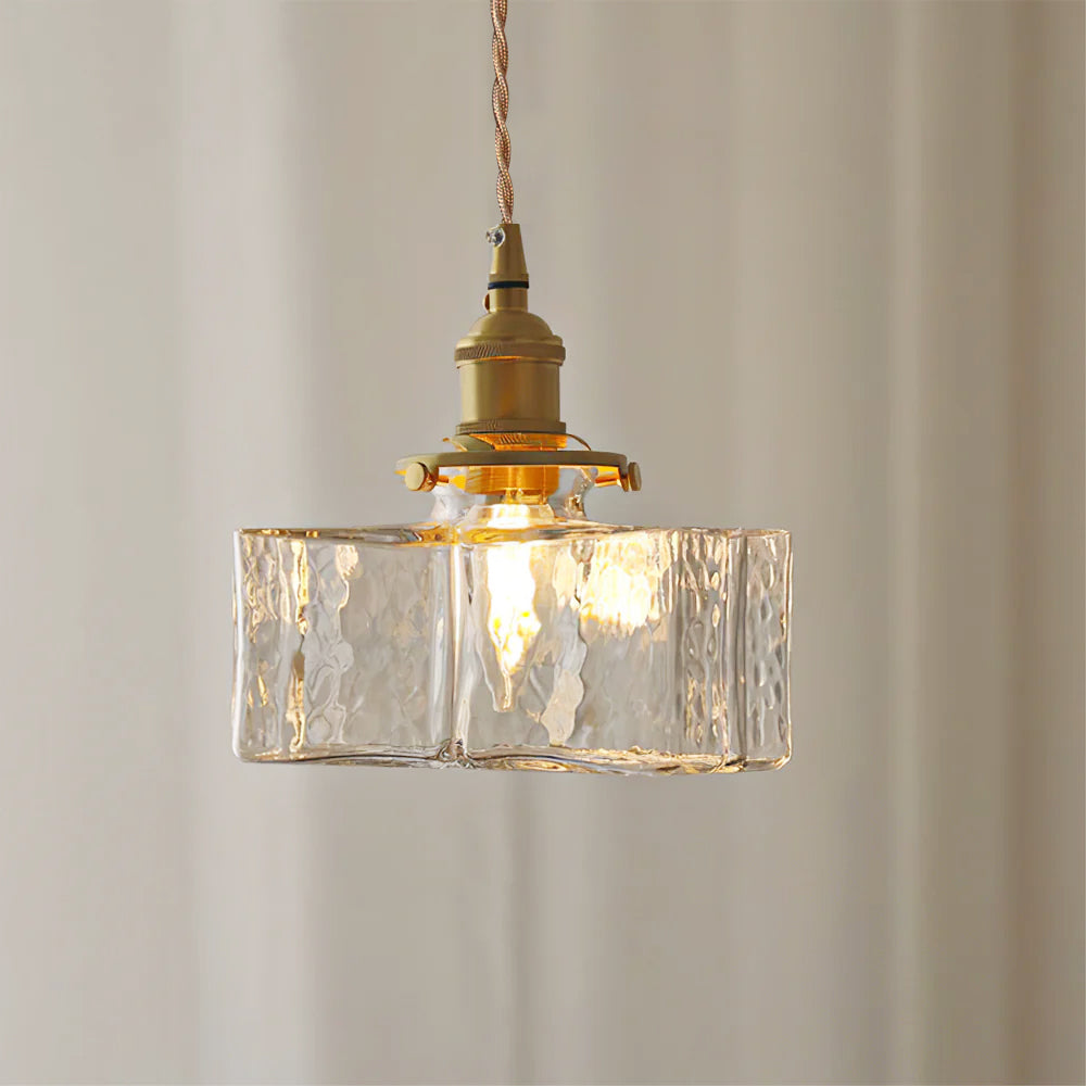 Clérachic boxy hammered-glass pendant light, Model B, lit against a soft pleated curtain backdrop.