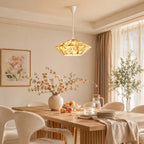This Clérachic pendant in beige floral fabric lights a long wooden dining table, beside tall curtains and a framed flower print.