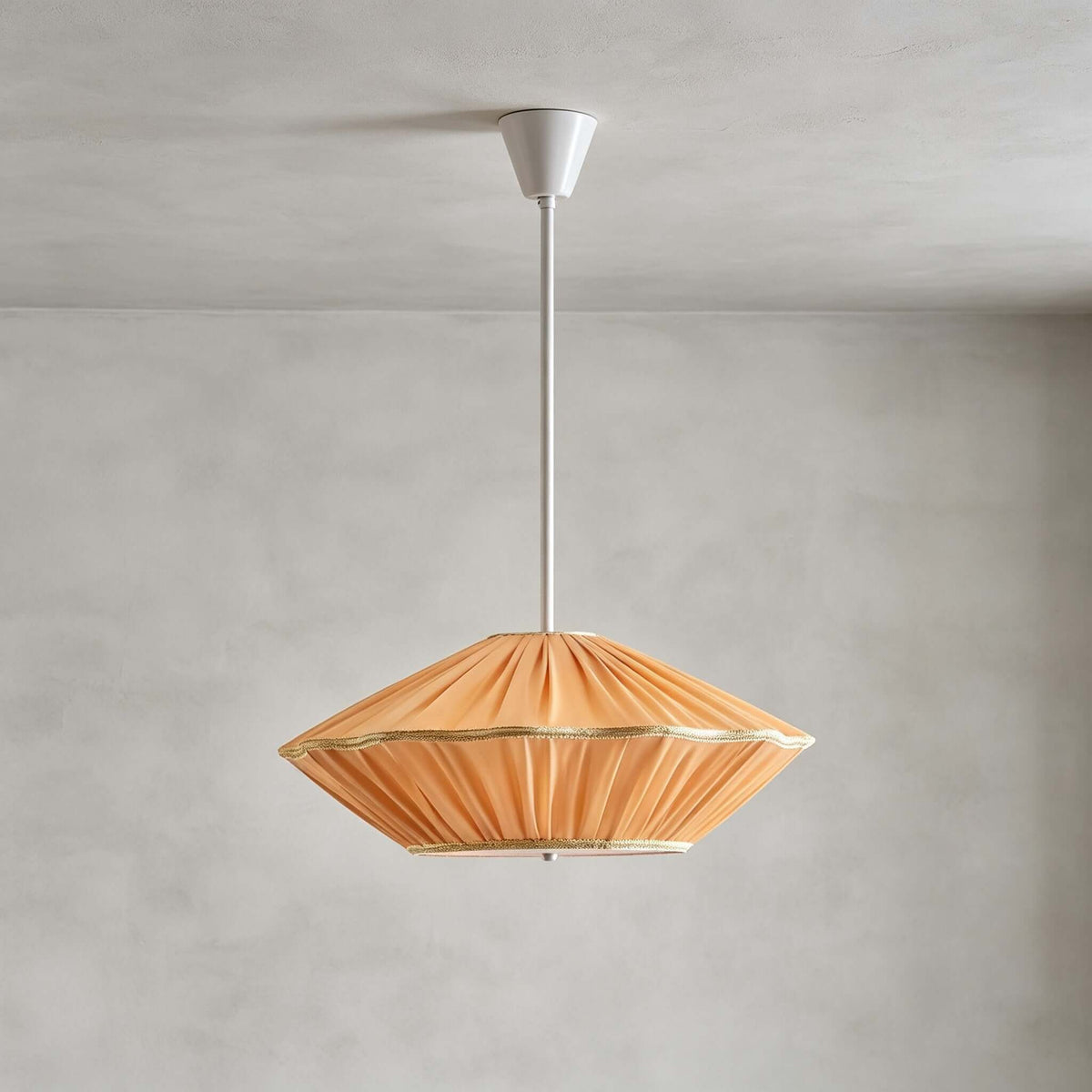 Orange pleated fabric with a gold trim edge on this Clérachic pendant, hung from a white rod and canopy on grey.