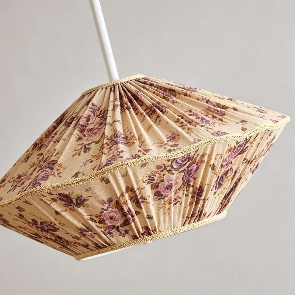 Close, angled view of the pleated rose-print fabric and gold braid trim on this Clérachic pendant shade.