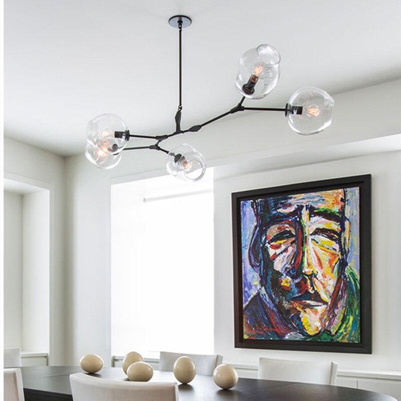 Clérachic branching bubble glass chandelier in black with five clear globes, lit above a dining table in a bright white room.