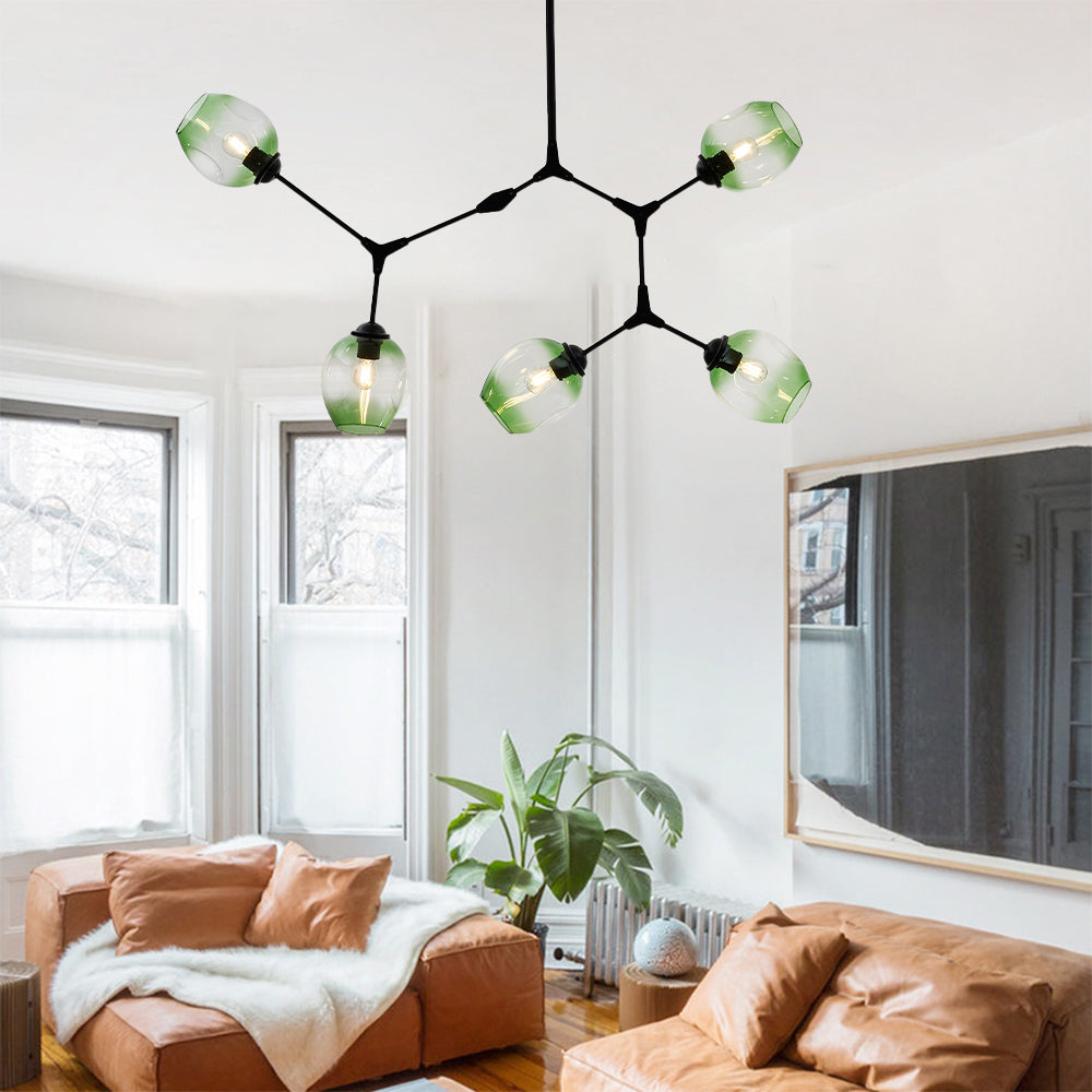 Clérachic chandelier in its five-head size, gradient green globes on black arms, lit above a room of tan leather sofas.