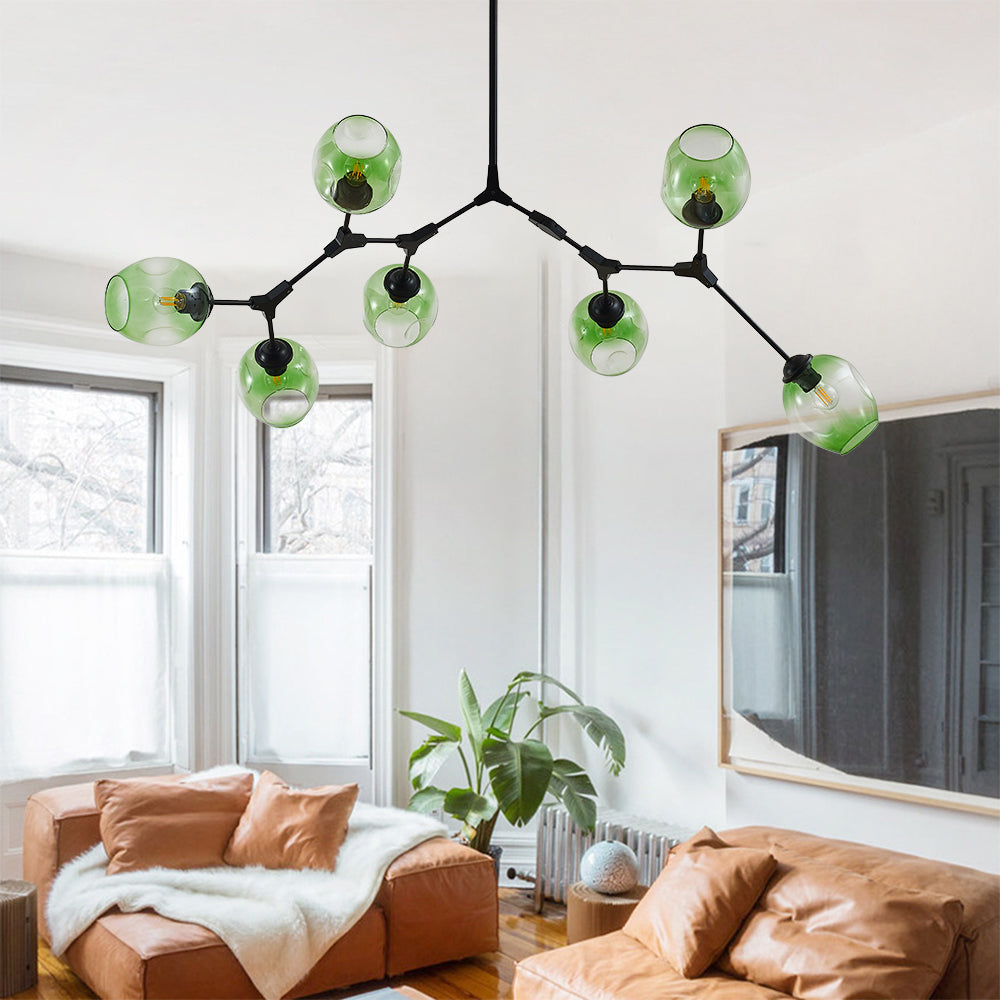 Seven gradient green globes branch from the black Clérachic frame, filling the ceiling above a bright sitting room.