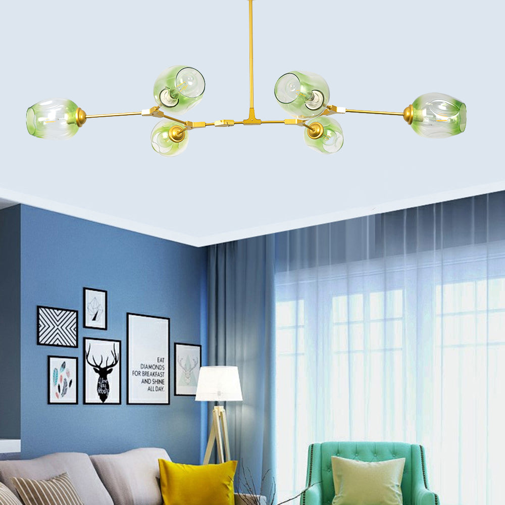 Gradient green globes on the gold Clérachic frame, lit against a blue wall hung with framed prints above a pale sofa.