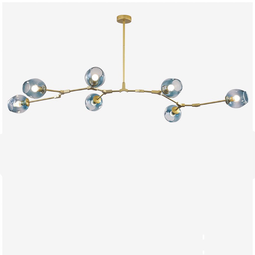 Studio shot of the gold Clérachic chandelier with gradient blue globes, arms cranked so no two heads sit level.