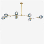 Studio shot of the gold Clérachic chandelier with gradient blue globes, arms cranked so no two heads sit level.