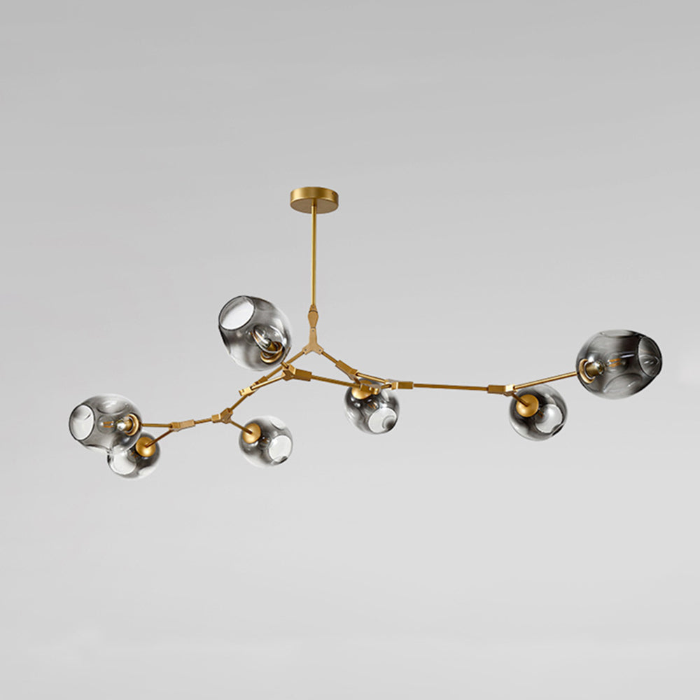 Unlit studio view of the Clérachic chandelier in gradient gray glass on gold arms, the branching shape read against grey.